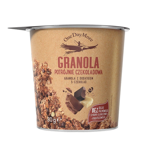 Knusprige Granola mit Dreifach-Schokolade von ONEDAYMORE, 80 g, mit Schokoladenstücken auf einer weißen Oberfläche.