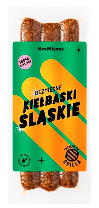 Vegetarische schlesische Bratwürste von BEZMIĘSNY MIĘSNY, 210 g, auf einem Teller mit Kräutern und Beilagen.