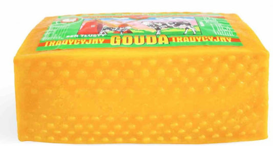 Gouda-Käse Block von ROSPUDA, traditionell hergestellt, ca. 3 kg, cremig und goldgelb, auf einem Holztisch liegend